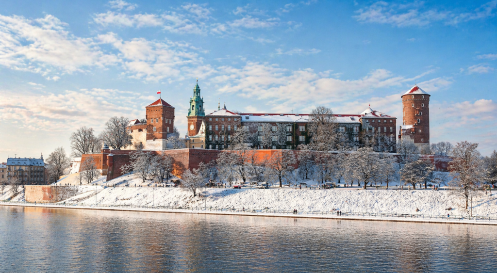 Wawel Hill Krakow - Wawel Castle in Krakow seen from the Vistula River in winter, with light snow and soft overcast sky.