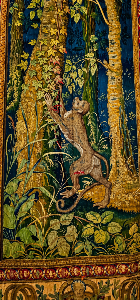 Fragment of a Wawel arras tapestry depicting a monkey among richly detailed foliage and trees.