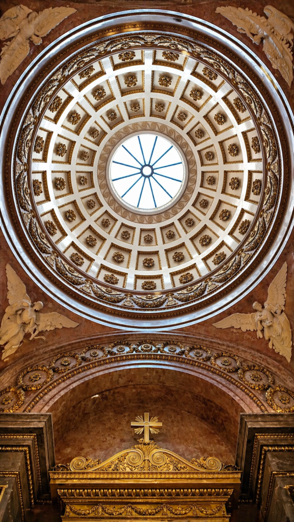 Ornate dome inside Wawel Cathedral in Krakow with detailed gold decorations and central skylight.