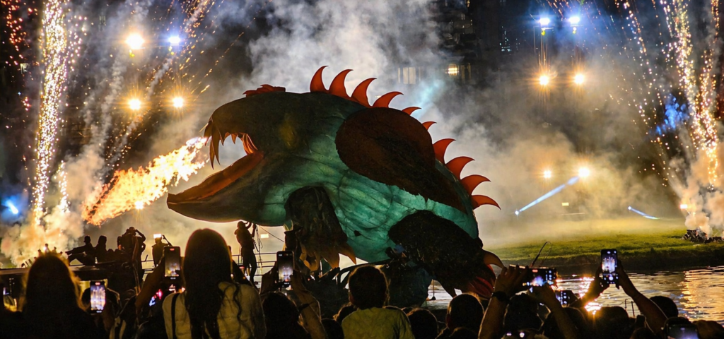 Great Dragon Parade in Krakow with a giant dragon breathing fire during a night show by the Vistula River.