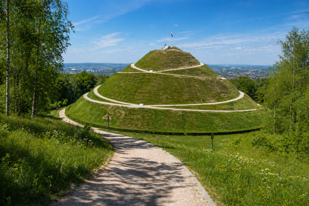 Piłsudski Mound in Krakow – panoramic view of the historic mound surrounded by forest, with walking paths leading to the top