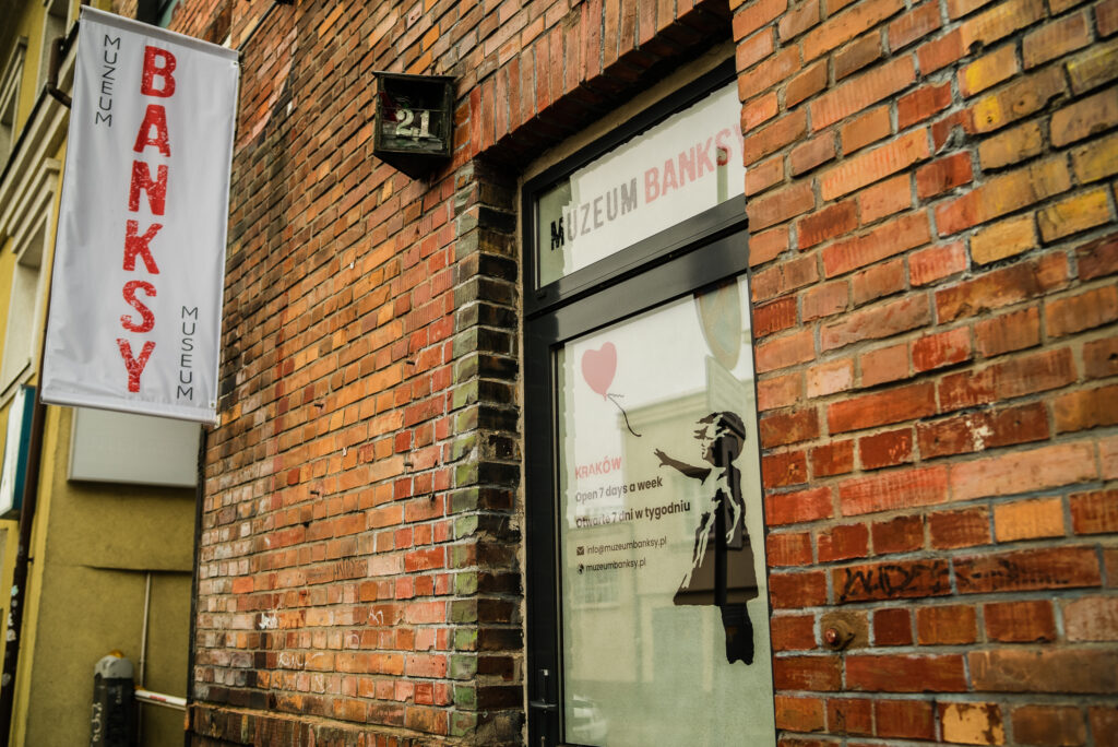 Entrance to the Banksy Museum in Krakow with distinctive street art-style signage.